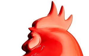 Close-up of a glossy red ceramic rooster sculpture against a white background.