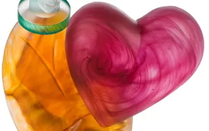 Amber glass vase paired with a pink swirled glass heart sculpture.
